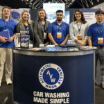 Team of professionals at the AVW booth showcasing car washing equipment and solutions at the Australia 2024 trade show, with a focus on customer service and innovation